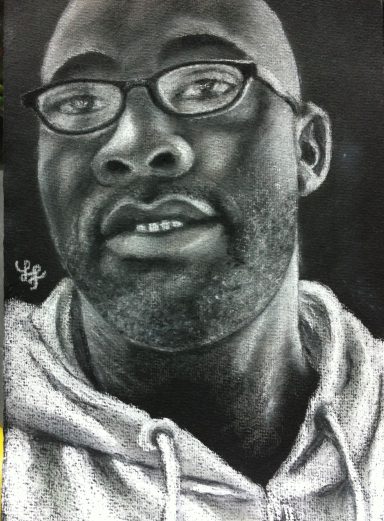 Porträt eines Mannes mit Brille und Bart, in einem grauen Hoodie.