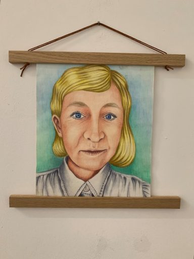 Porträt einer Person mit blonden Haaren und blauen Augen, trägt ein weißes Hemd.