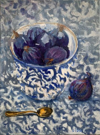 Schüssel mit Feigen und einem Löffel, vor einem blauen, marmorierten Hintergrund.